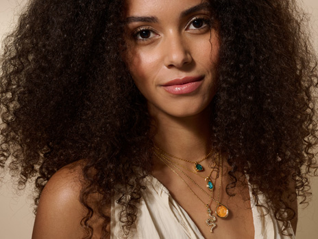 Woman wearing Golden Mango, snake necklace and aqua crystal jewelry